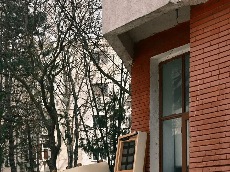 Old armchair and sofa left outside a brick building